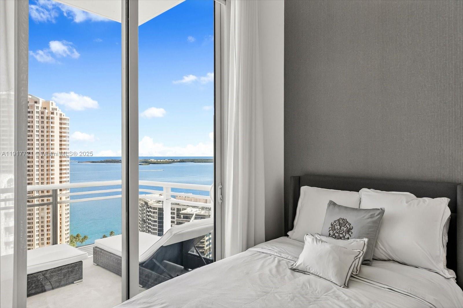 900 Brickell Key Boulevard, Unit 2304 Miami, FL 33131 - Photo 20 of 55 a bedroom with a bed and glass walk in closet