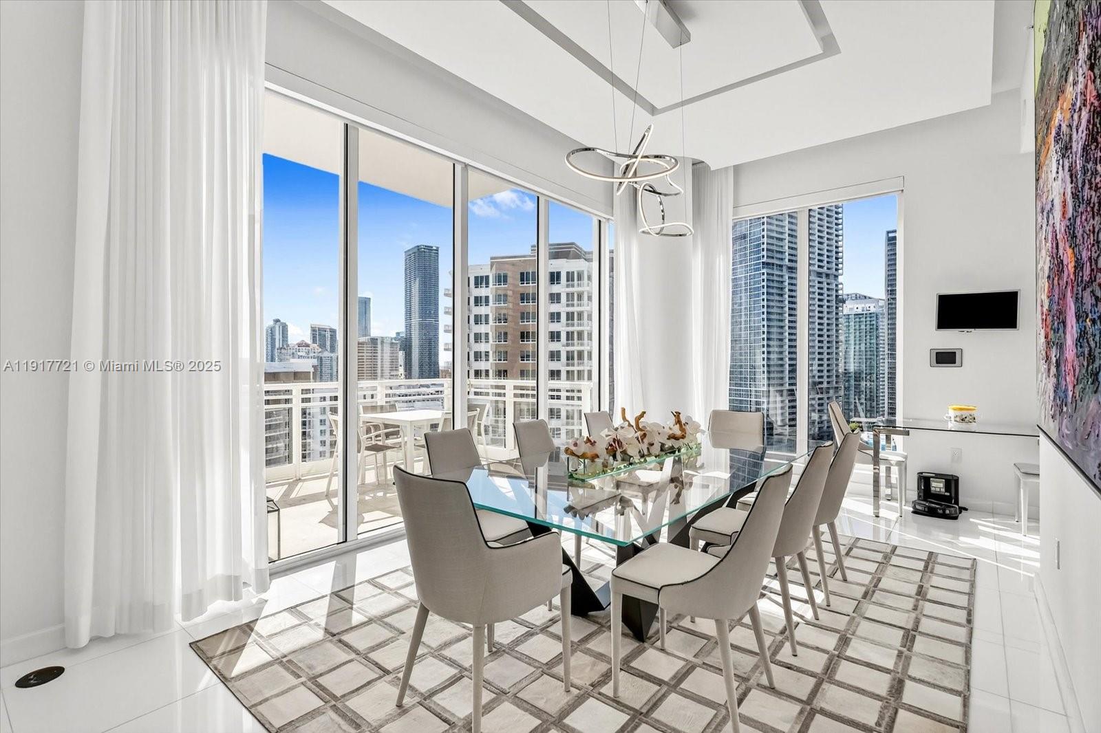 900 Brickell Key Boulevard, Unit 2304 Miami, FL 33131 - Photo 8 of 55 a dining room with furniture and large windows