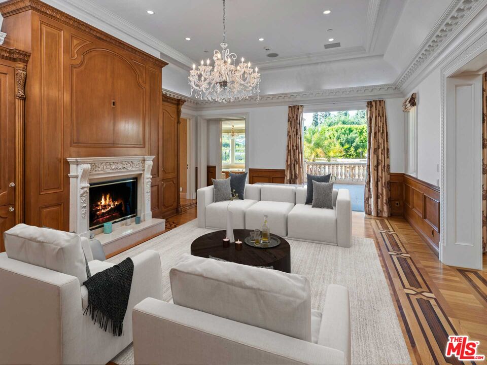 901 North Alpine Drive Beverly Hills, CA 90210 - Photo 27 of 33 a living room with furniture a chandelier and a fireplace
