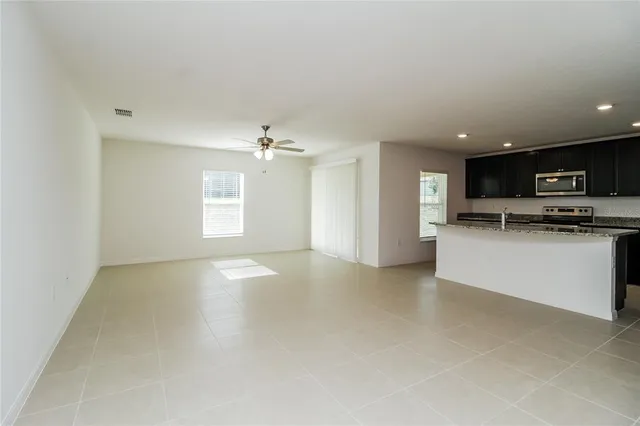 a view of a kitchen with a sink and dishwasher a stove top oven with wooden floor