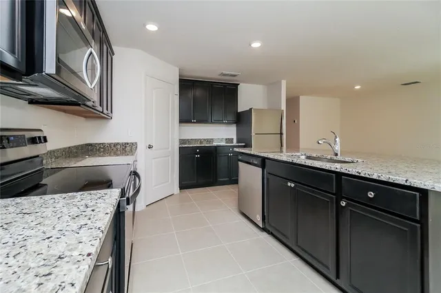 a kitchen with stainless steel appliances granite countertop a sink and a stove