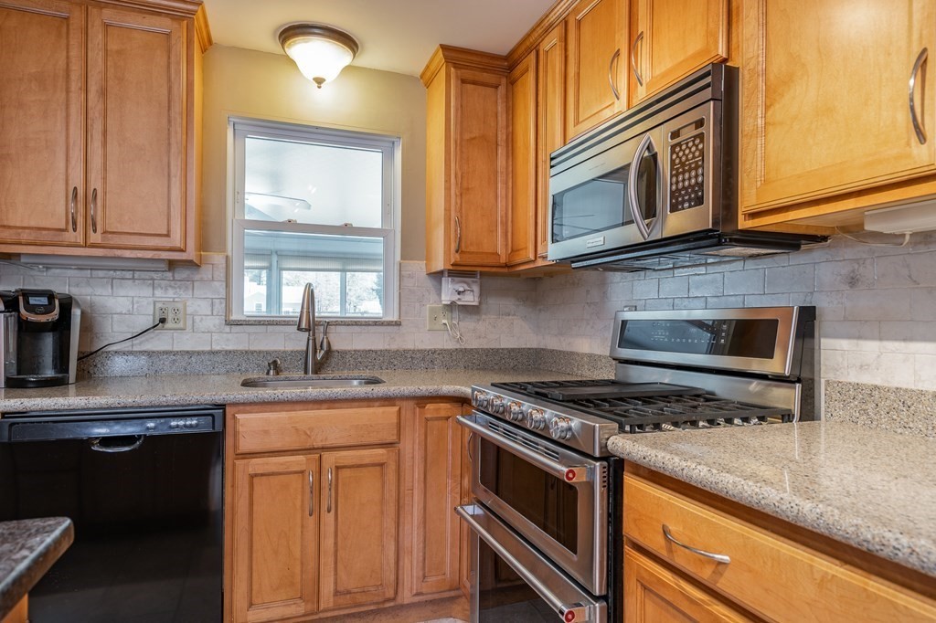 30 County Road Holyoke, MA 01040 - Photo 15 of 38 a kitchen with stainless steel appliances granite countertop a sink stove and microwave
