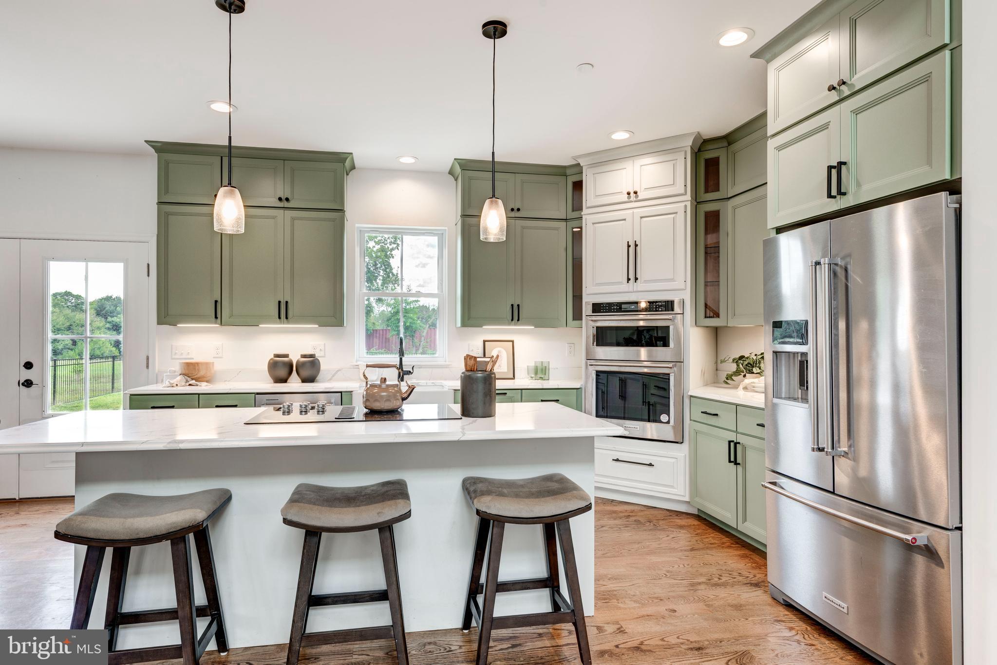 1865 Hughes Shop Road Westminster, MD 21158 - Photo 21 of 46 a kitchen with stainless steel appliances a dining table chairs refrigerator and sink