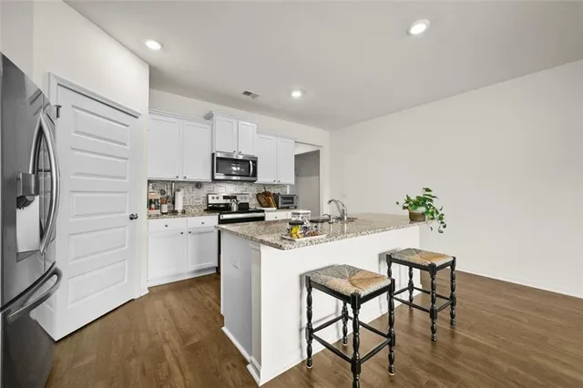 a kitchen with white cabinets and stainless steel appliances
