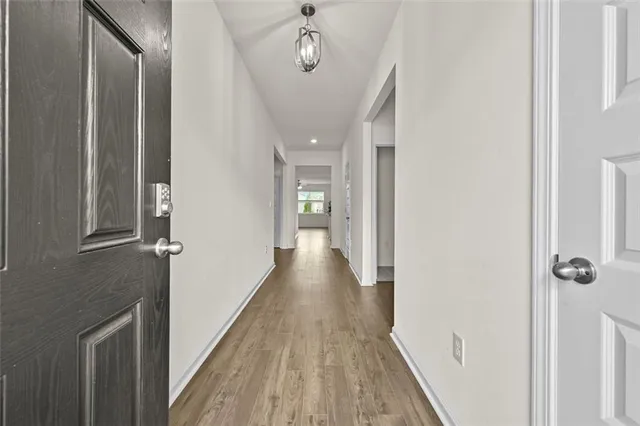 a view of a hallway with wooden floor and staircase