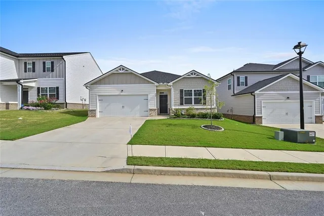 an aerial view of residential houses with outdoor space and parking