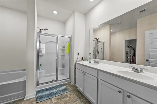 a bathroom with a double vanity sink mirror and shower