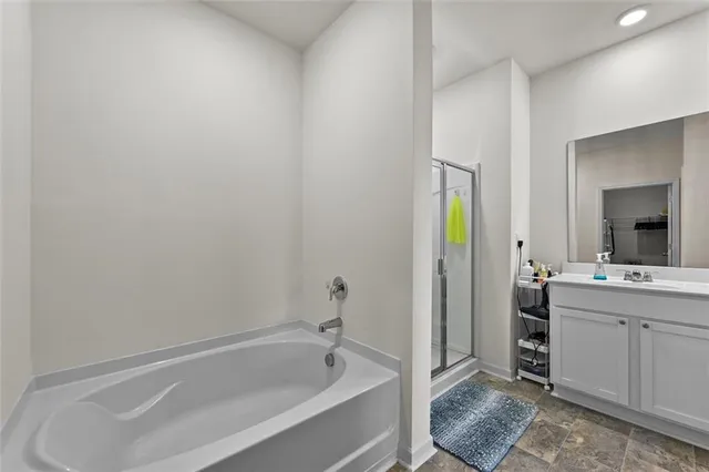 a bathroom with a tub sink and mirror