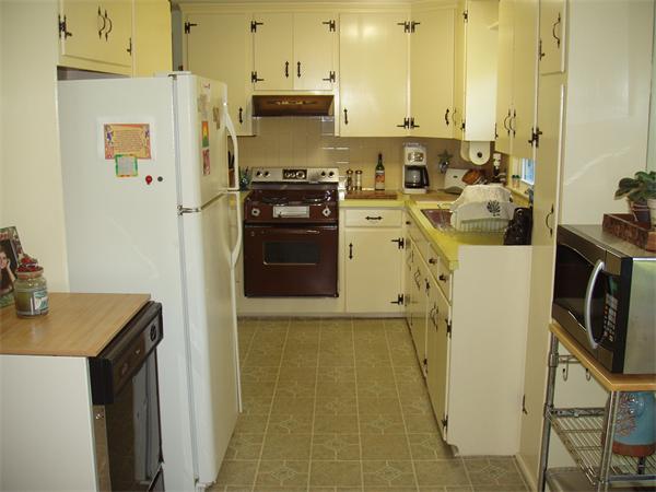 496 Harvard Road Lancaster, MA 01523 - Photo 9 of 12 a kitchen with a refrigerator a stove a sink dishwasher and wooden cabinets