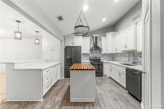 a kitchen with stainless steel appliances a stove refrigerator and cabinets