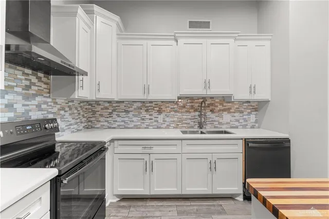 a kitchen with granite countertop white cabinets and a stove