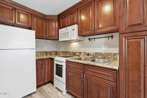a kitchen with stainless steel appliances granite countertop a refrigerator and a stove top oven