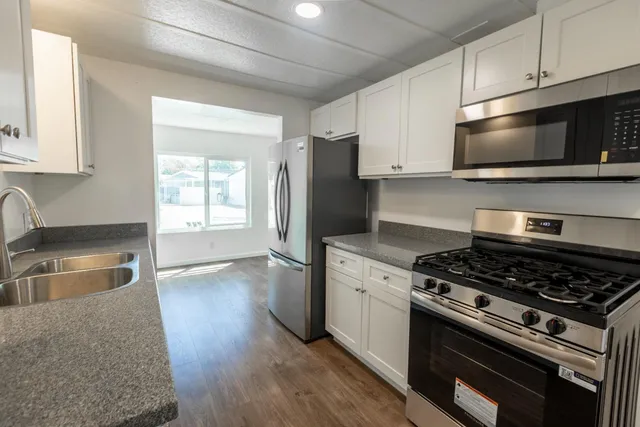 a kitchen with stainless steel appliances a stove a microwave and sink