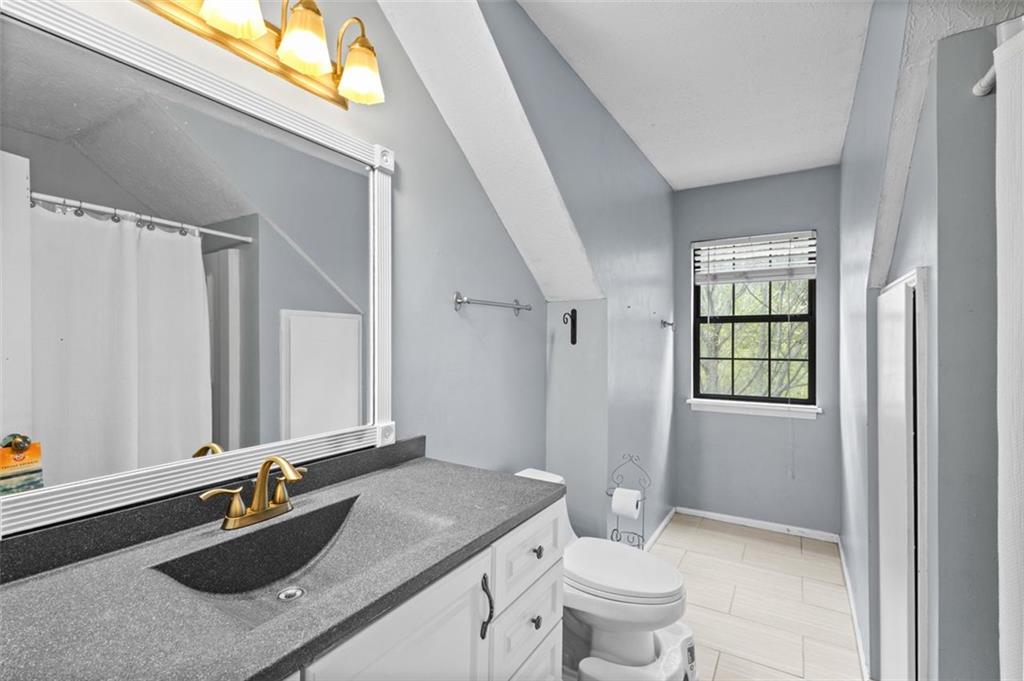 2888 Cardinal Trace Duluth, GA 30096 - Photo 34 of 51 a bathroom with a granite countertop sink a large mirror a toilet and a window