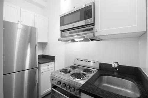 a kitchen with a refrigerator and a stove top oven