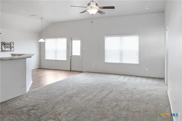 wooden floor in an empty room with a kitchen