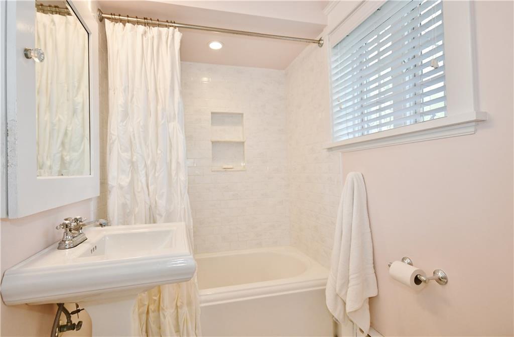 6623 Kinsman Road Pittsburgh, PA 15217 - Photo 22 of 25 a bathroom with a bathtub a sink and a window