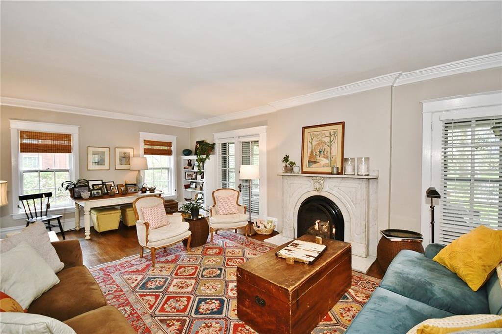6623 Kinsman Road Pittsburgh, PA 15217 - Photo 6 of 25 a living room with couches a fireplace and a dining table with wooden floor