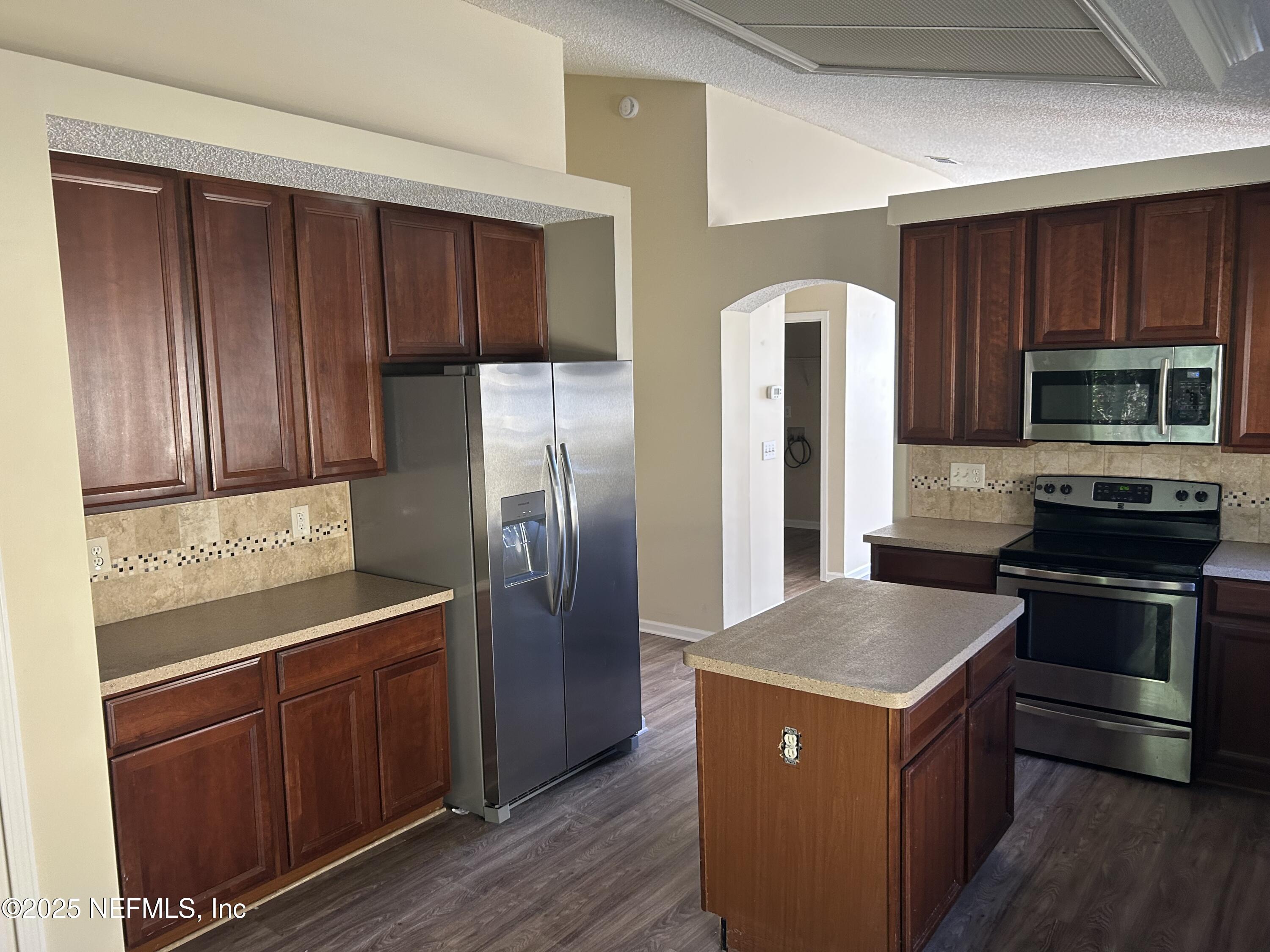 1425 Laurel Oak Drive Fleming Island, FL 32003 - Photo 11 of 25 a kitchen with stainless steel appliances granite countertop a refrigerator a stove and wooden cabinets