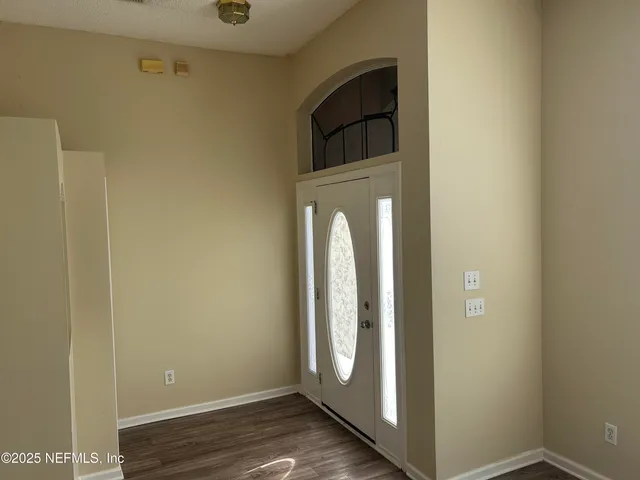 a view of a hallway with wooden floor and closet