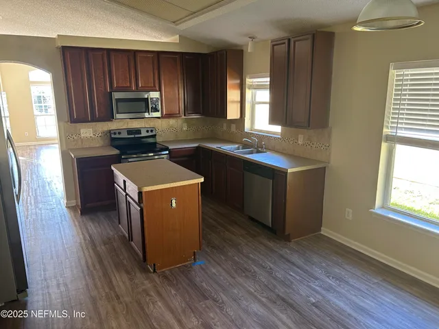a kitchen with wooden floors and wooden cabinets