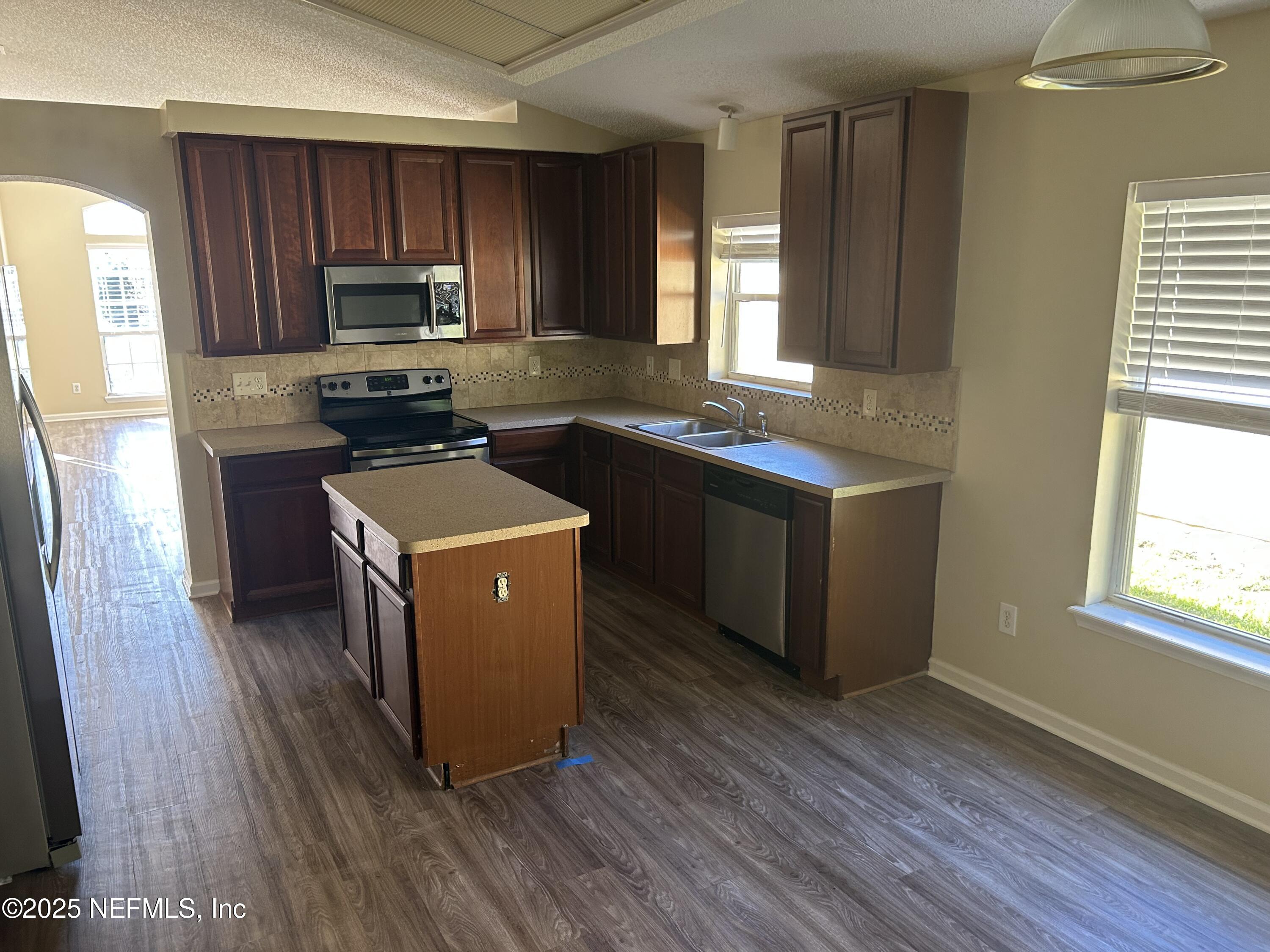 1425 Laurel Oak Drive Fleming Island, FL 32003 - Photo 9 of 25 a kitchen with wooden floors and wooden cabinets