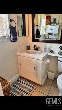 a bathroom with a toilet a sink and mirror