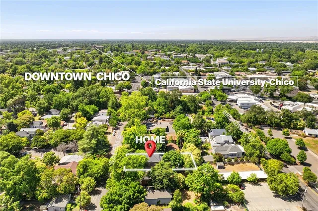 an aerial view of residential houses with outdoor space and trees