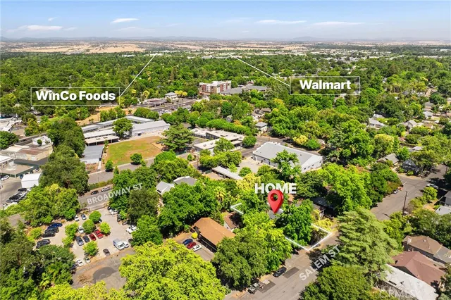 an aerial view of residential houses with outdoor space and trees