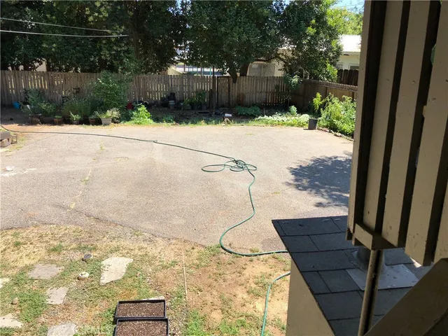 a view of a yard with wooden fence
