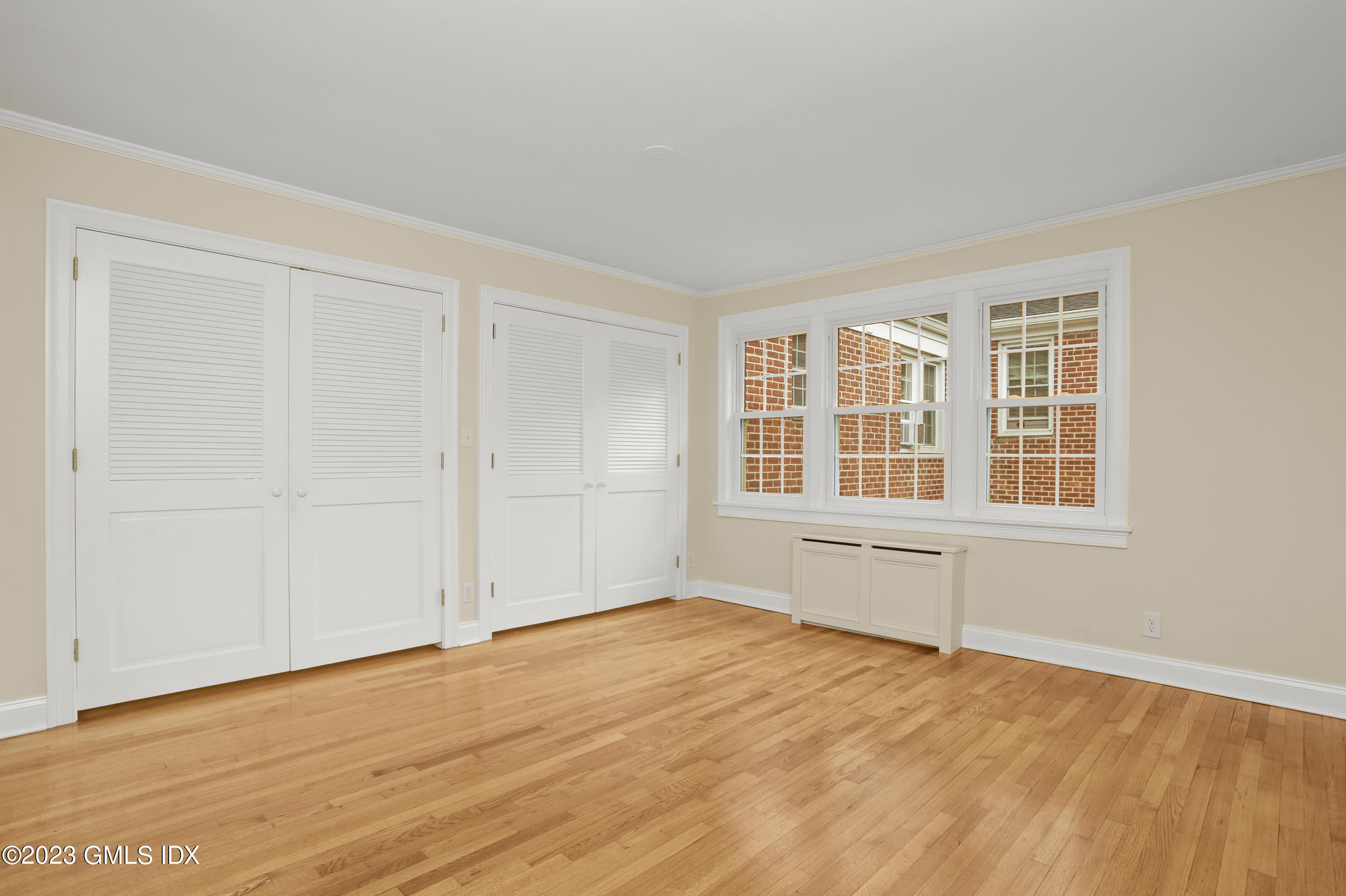 149 Putnam Park, Unit 149 Greenwich, CT 06830 - Photo 27 of 43 an empty room with wooden floor and windows