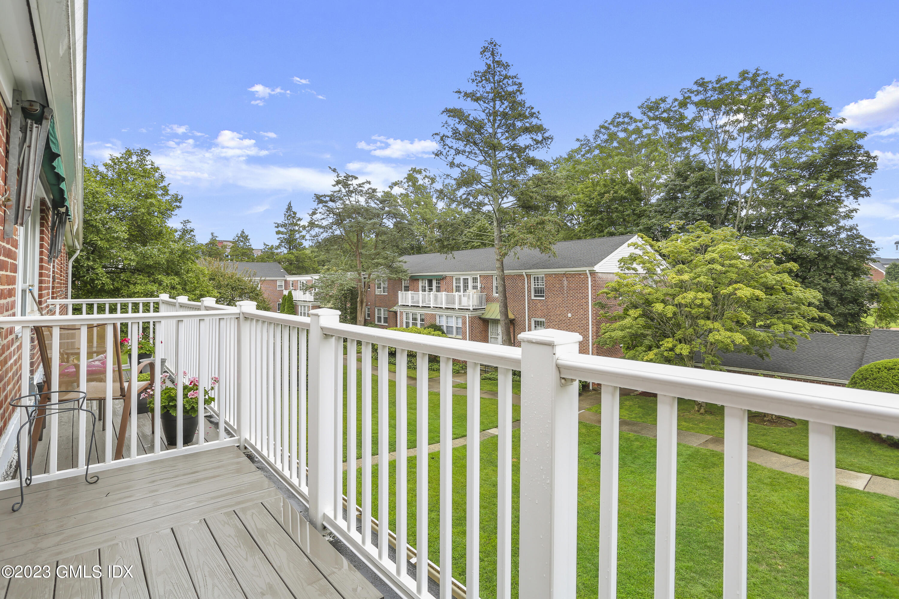 149 Putnam Park, Unit 149 Greenwich, CT 06830 - Photo 36 of 43 a balcony with wooden floor and fence