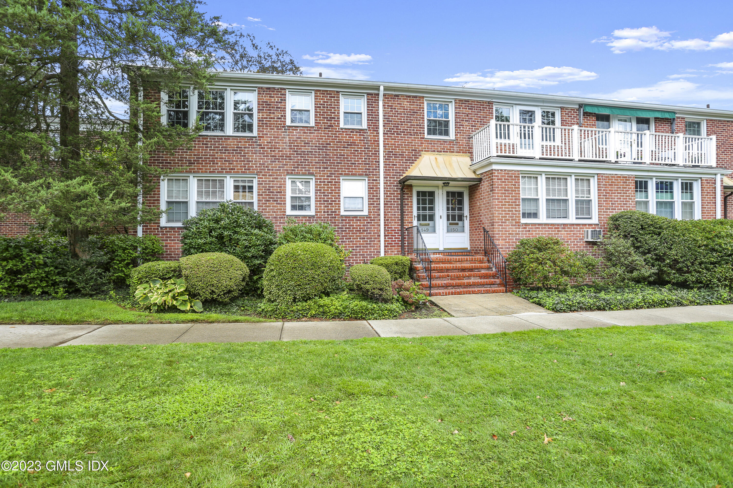 149 Putnam Park, Unit 149 Greenwich, CT 06830 - Photo 42 of 43 a front view of a house with a yard and potted plants