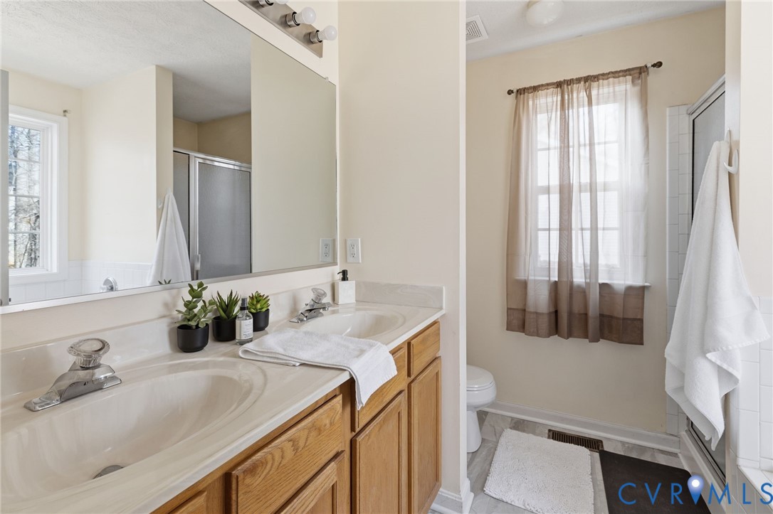 504 Gloucester Drive Ruther Glen, VA 22546 - Photo 11 of 28 a bathroom with a granite countertop sink and a mirror