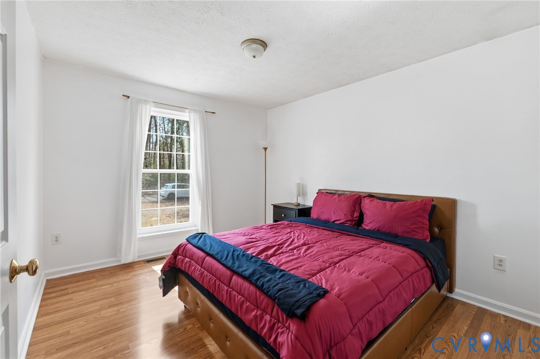 504 Gloucester Drive Ruther Glen, VA 22546 - Photo 15 of 28 a bedroom with a bed and wooden floor