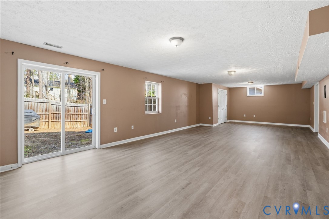 504 Gloucester Drive Ruther Glen, VA 22546 - Photo 18 of 28 a view of an empty room with wooden floor and a window