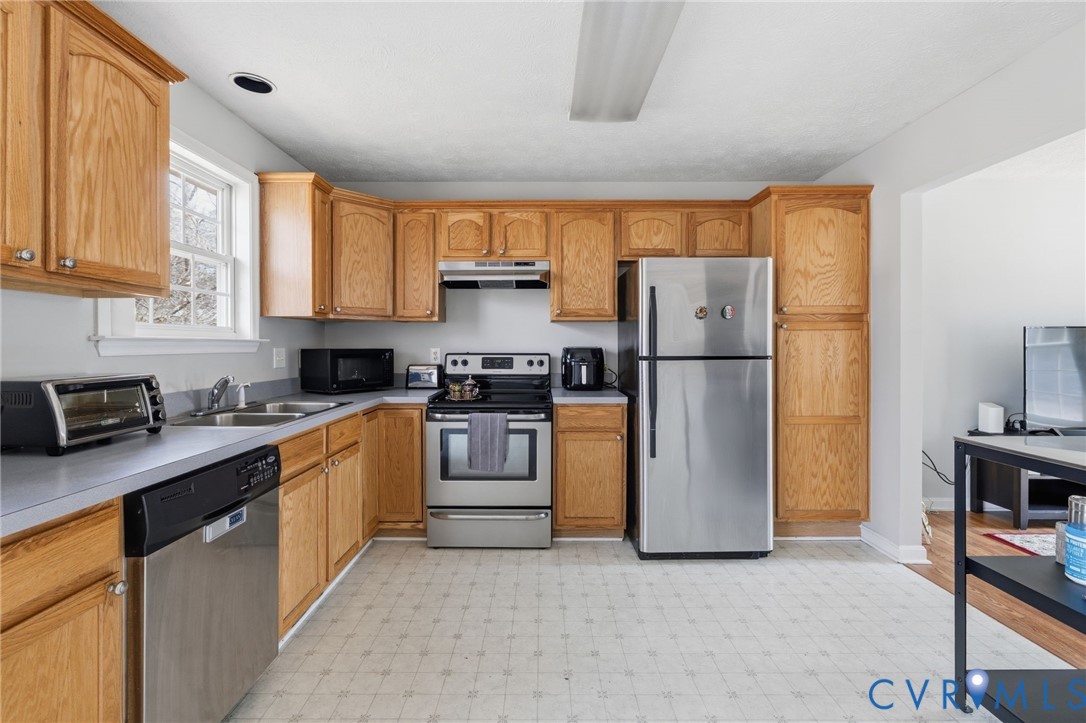 504 Gloucester Drive Ruther Glen, VA 22546 - Photo 8 of 28 a kitchen with stainless steel appliances granite countertop a refrigerator sink and stove