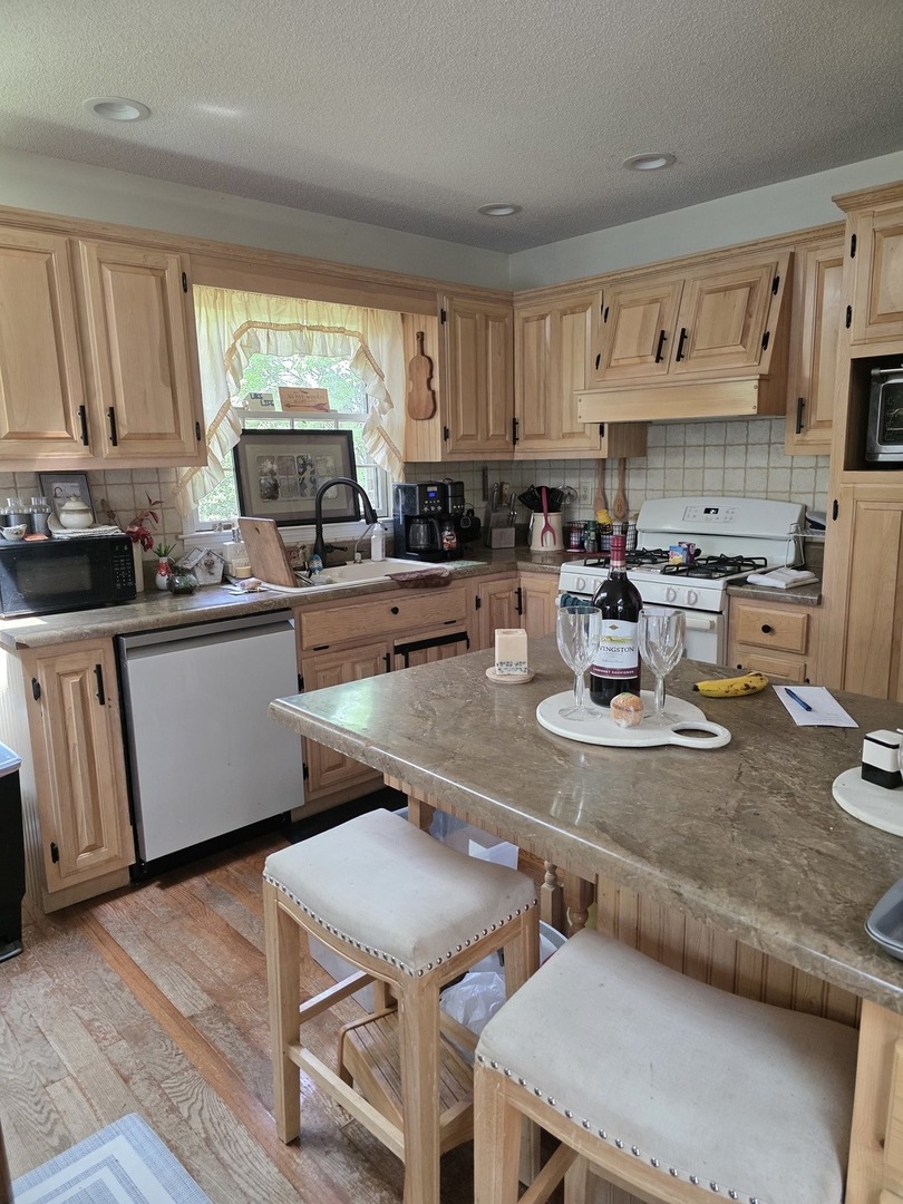 107 Comanche Trail Loda, IL 60948 - Photo 8 of 37 a kitchen with kitchen island a stove a sink a refrigerator and cabinets