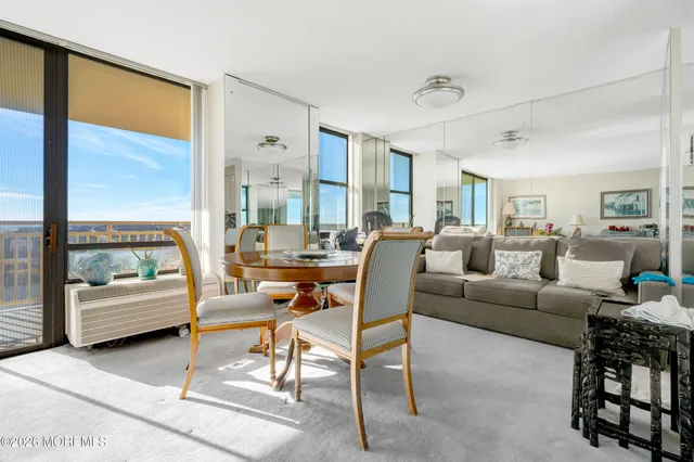 a dining room with furniture and a floor to ceiling window