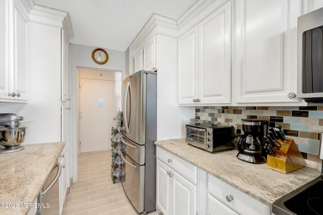 a kitchen with stainless steel appliances granite countertop a stove a sink and a white cabinets