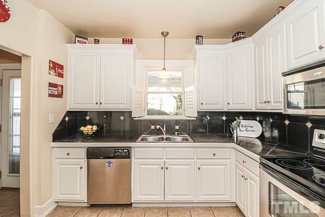 a kitchen with stainless steel appliances white cabinets and a sink