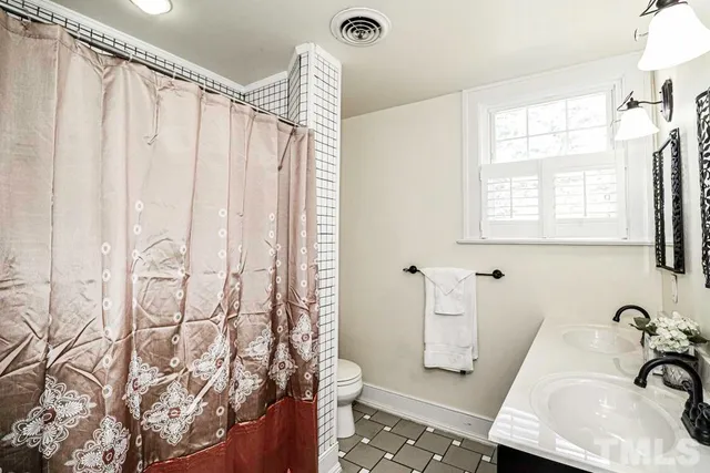 a bathroom with a granite countertop sink and a tub