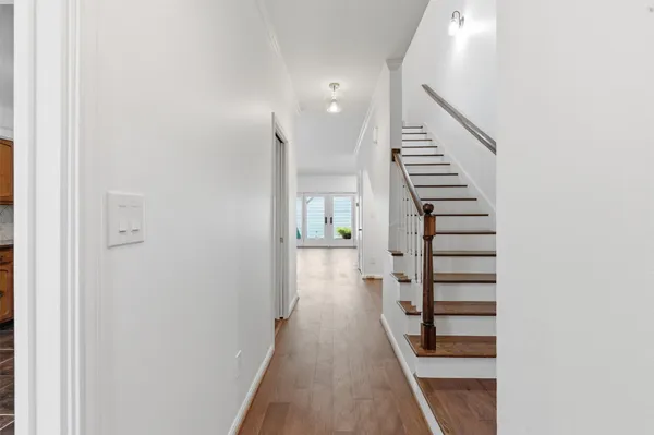 a view of a hallway with wooden floor and entryway