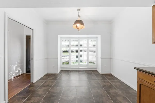 a view of an empty room with closet and a window