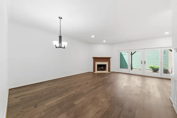 a view of empty room with wooden floor and fireplace
