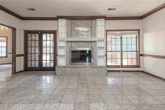 a view of an empty room with a fireplace and a window