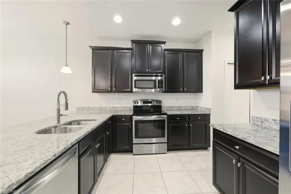 a kitchen with kitchen island a counter top space appliances and cabinets