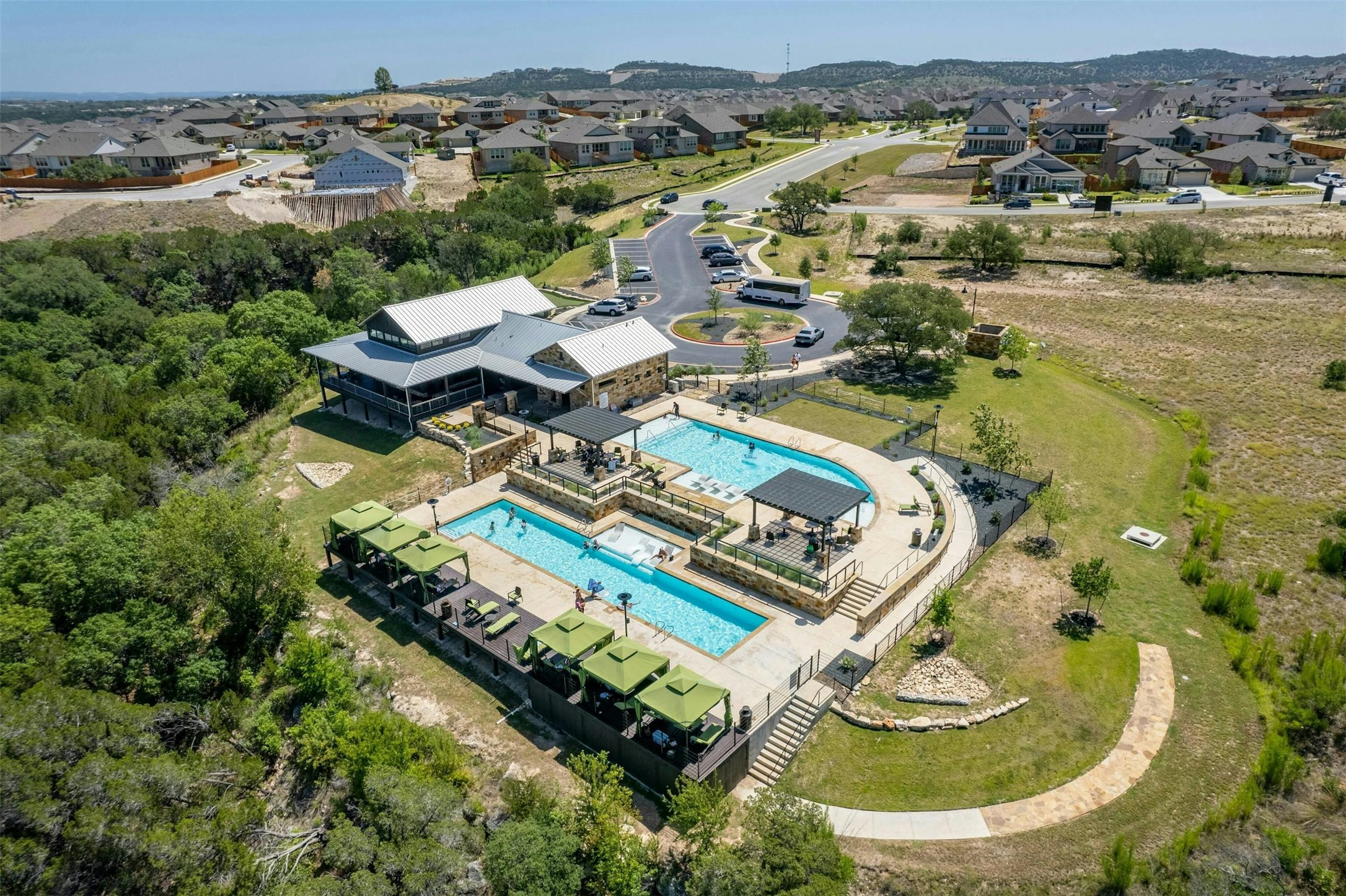 19113 Freeman Circle Austin, TX 78738 - Photo 32 of 37 Overlook Club - An aerial perspective reveals a vibrant community hub with multiple swimming pools, cabanas, and a contemporary clubhouse.