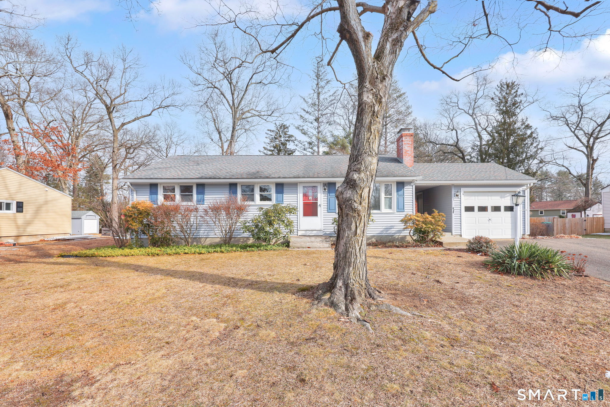 a front view of a house with a yard and potted plants