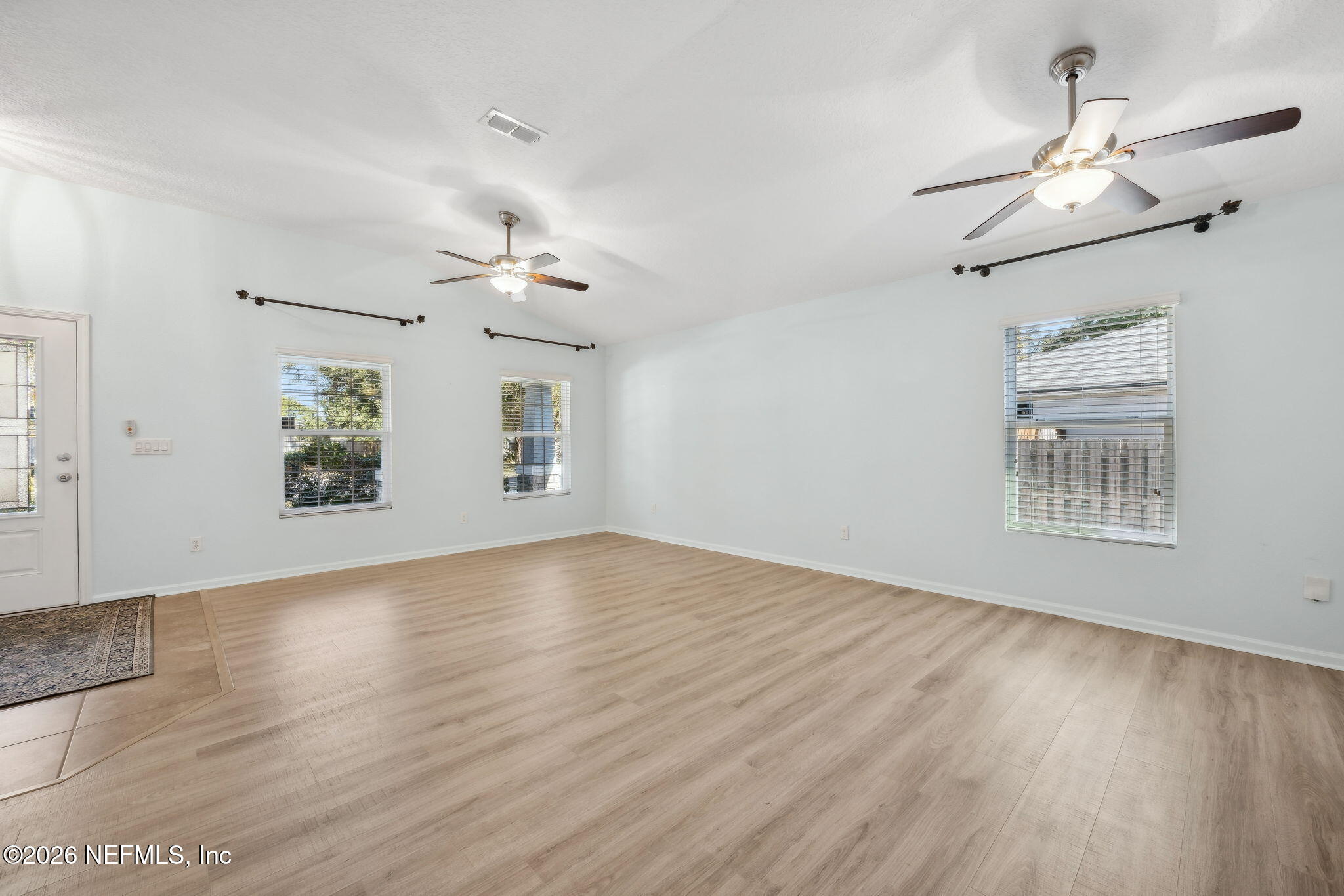 1602 Indigo Street Fernandina Beach, FL 32034 - Photo 12 of 35 an empty room with wooden floor chandelier fan and windows